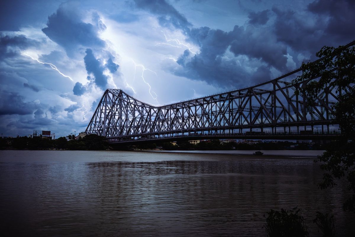 The Howrah Bridge under a heavy sky, the river flat beneath it
