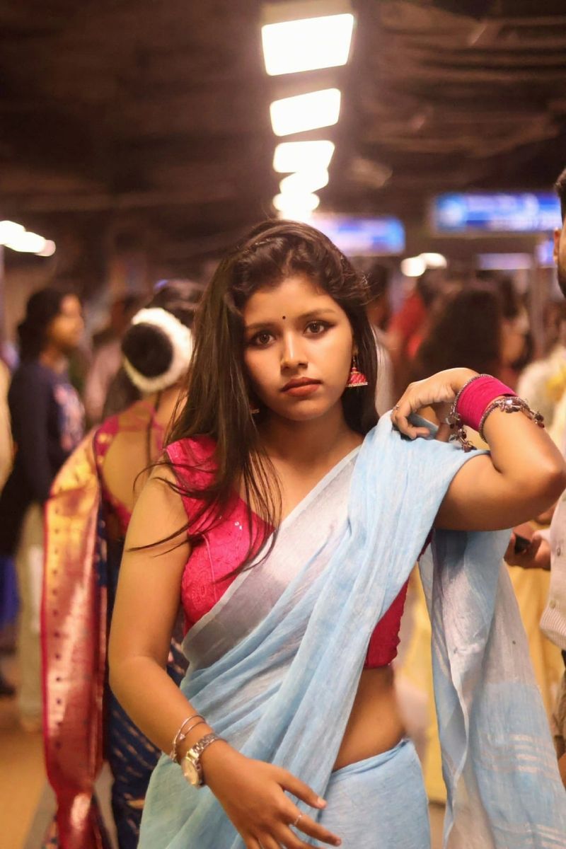 A portrait in a sari, lit by the shop lights of a busy market